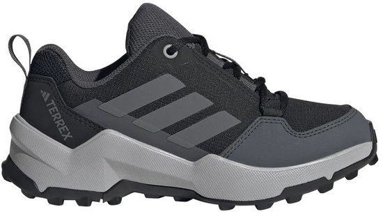 Zij-aanzicht van een zwarte Terrex wandelschoen met grijze Adidas strepen en een grijze zool.