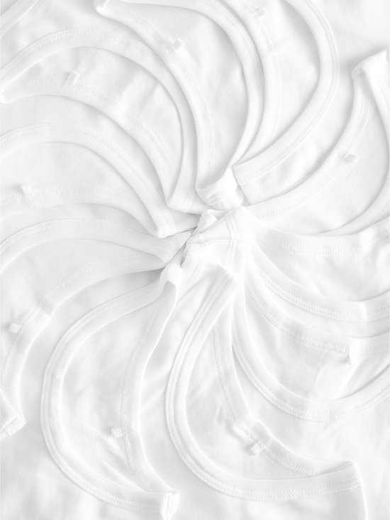 Witte katoenen hemdjes gerangschikt in een cirkelvormig patroon.