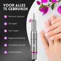 Zilverkleurige elektrische nagelvijl met roze accenten naast handen met manicure. Voor nagels en eelt.