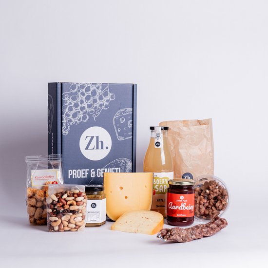 Kerstpakket met kaas, worst, sap, jam, noten en snacks, met de tekst 'Zuivelhoeve' op de doos.