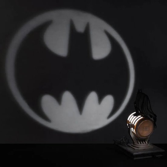 Schaduw van het vleermuislogo van Batman geprojecteerd op een muur, met de lamp ernaast.