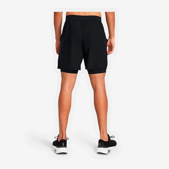 Achterkant van een man in donkergrijs gemêleerd T-shirt en zwarte sportbroek.