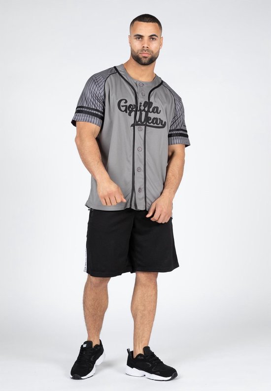 Man met grijze baseball jersey met zwarte opdruk 'Gorilla Wear', gestreepte mouwen en zwarte shorts.