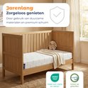 Houten babybed met matras, plaid en teddybeer. Tekst: Jarenlang zorgeloos genieten.