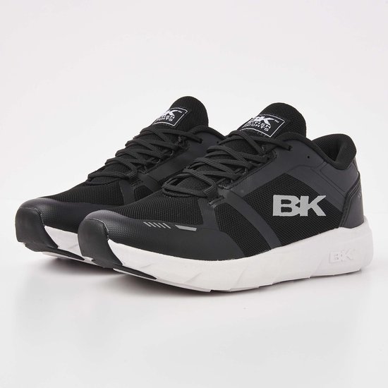Een paar zwarte lage sneakers met witte zolen en zilveren BK logo's.