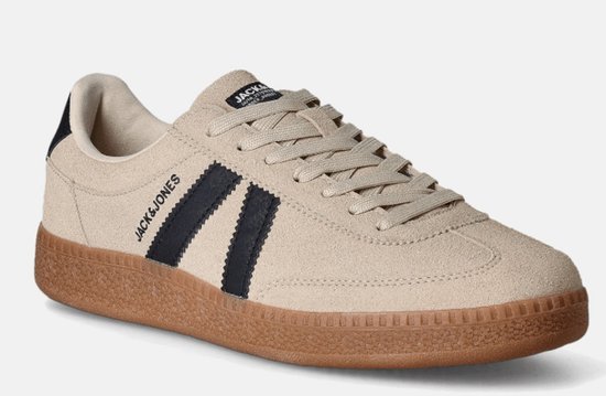 Crèmekleurige leren sneaker met zwarte strepen, bruine zool en 'Jack & Jones' logo op de zijkant.