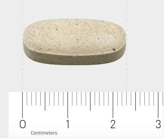 Close-up van een ovalen, lichtbruin vitamine C tablet met een schaalverdeling in centimeters.
