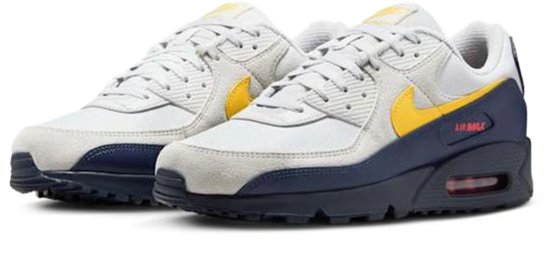 Grijze Nike Air Max 90 sneakers met gele swoosh, donkerblauwe overlays en Air Max-unit.