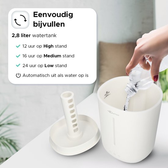 Een hand vult het 2,8L waterreservoir van de witte Qumax luchtbevochtiger bij. Makkelijk bij te vullen, schakelt automatisch uit.