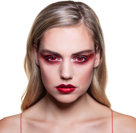 Vrouw met make-up met rode oogschaduw en lippen, draagt rode ooglenzen.