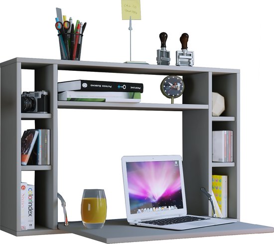 Grijze wandbureau open met laptop, glas, boeken, pennen, camera en klok. Klapblad met scharnieren.