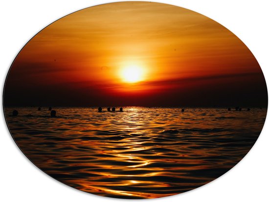 WallClassics - Dibond Ovaal - Zwemmende Mensen in Zee bij Ondergaande Zon - 80x60 cm Foto op Ovaal (Met Ophangsysteem)