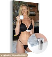 MuchoWow® Glasschilderij 80x120 cm - Schilderij acrylglas - Een jonge vrouw in een zwarte bikini met een kopje koffie - Foto op glas - Schilderijen