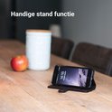 Zwarte telefoonhoes in standfunctie met een telefoon die een startscherm weergeeft.