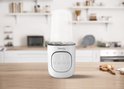 Witte "Thermup 2.0" flesverwarmer op een houten aanrecht in een moderne keuken.