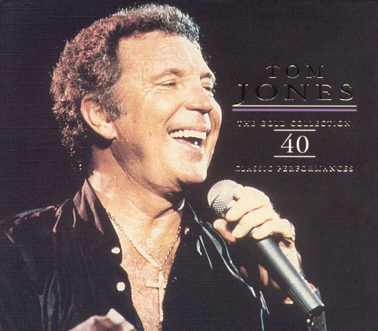 Tom Jones, de zanger, lacht met een microfoon in zijn hand. Tekst: Tom Jones, The Gold Collection, 40 Classic Performances.