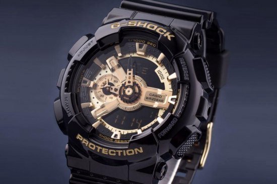 Zwart G-Shock horloge met glanzende band en gouden wijzerplaat, op donkerblauwe achtergrond.