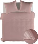 Roze dekbedovertrek met twee kussens, opgemaakt op een bed.