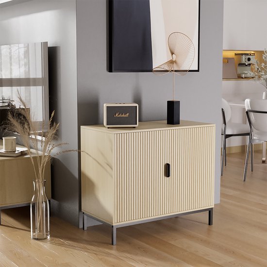 Eikenhouten dressoir met verticale ribbels, zwarte handgrepen en zwarte pootjes, in een gestyled interieur.