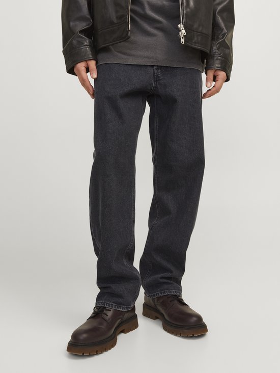 Dichtbij opname van de tailleband en broekzakken van een losse zwarte denim jeans.
