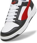 Close-up van de neus van de wit-zwarte PUMA Rebound v6 met rode PUMA-streep en veters.