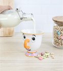Du lait est versé dans un mug blanc avec le visage de Chip, nez orange et base colorée.