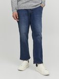 Man met blauwe jeans, grijze trui en witte sneakers.