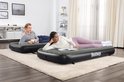 Man en vrouw liggen op twee aparte Bestway luchtbedden. Het linker bed is grijs, het rechter bed is donkergrijs met het Bestway logo.