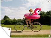 Tuinposter - Tuindoek - Tuinposters buiten - Vrouw fietsend met een flamingo zwemband om haar heen - 120x90 cm - Tuin