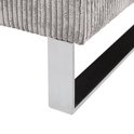Close-up van de verchroomde metalen poot van een grijze corduroy fauteuil.