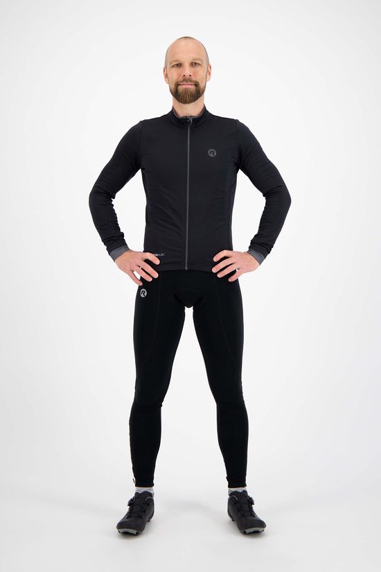 Man in zwart fietsjack en fietsbroek met logo's, handen in de zij.