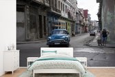 Behang - Fotobehang Een uitzicht op het straatbeeld met een Cubaanse oldtimer - Breedte 525 cm x hoogte 350 cm