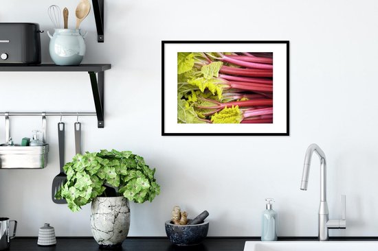 Une photo encadrée montre un gros plan de tiges de rhubarbe rouge avec des feuilles vert clair.