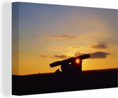 Canvas Schilderij Een zonsondergang bij een hunebed - 60x40 cm - Wanddecoratie