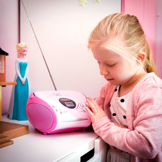 Meisje met roze vest luistert naar roze Lenco radio CD-speler.