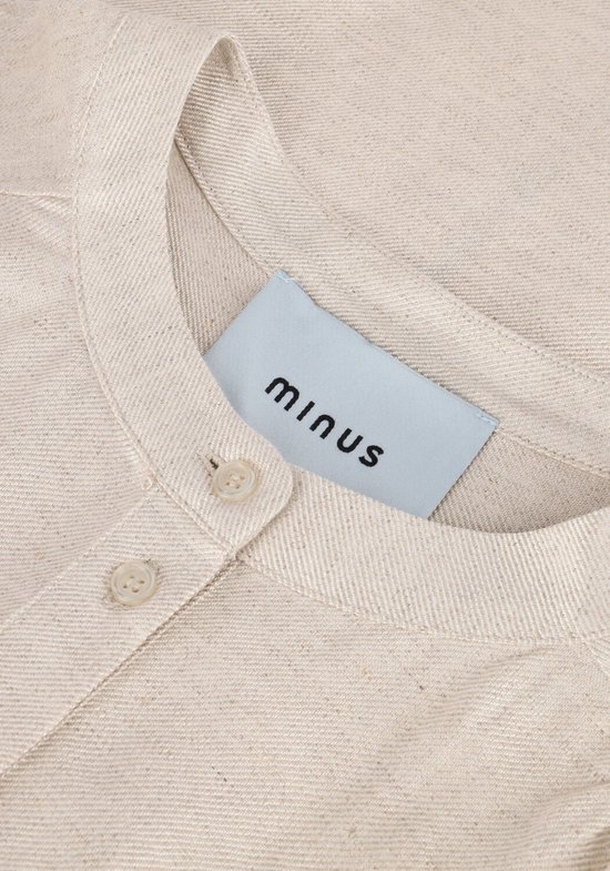 Close-up van de kraag en knoopjes van een beige linnen blouse met Minus-label.