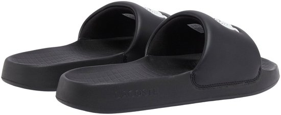 Paar zwarte Lacoste slippers met witte krokodil op de band, van voren gezien.