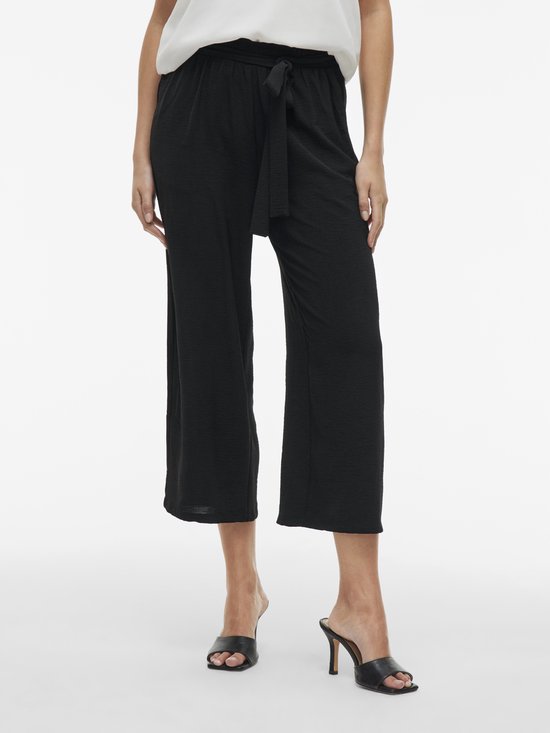 Zwarte culotte broek met strikceintuur, gedragen door een model.