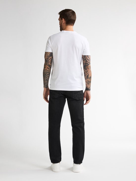 Man met witte t-shirt en zwarte jeans, van achteren gezien.
