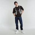 Man met donkerblauwe G-Star Mosa Straight jeans, zwart T-shirt met print, zwarte muts en witte laarzen.