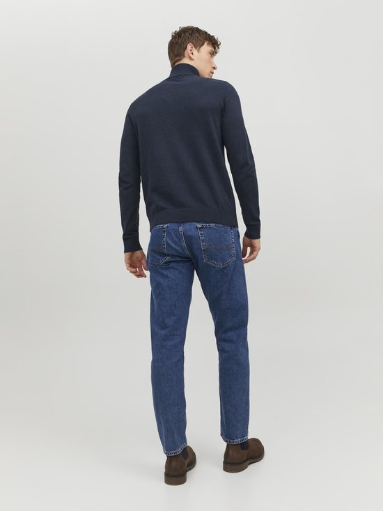 Man met de rug naar de camera, draagt donkerblauwe coltrui en jeans