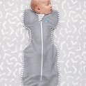 Baby slaapt in grijze Swaddle UP slaapzak met streepjesrand op grijze achtergrond met streepjespatroon.