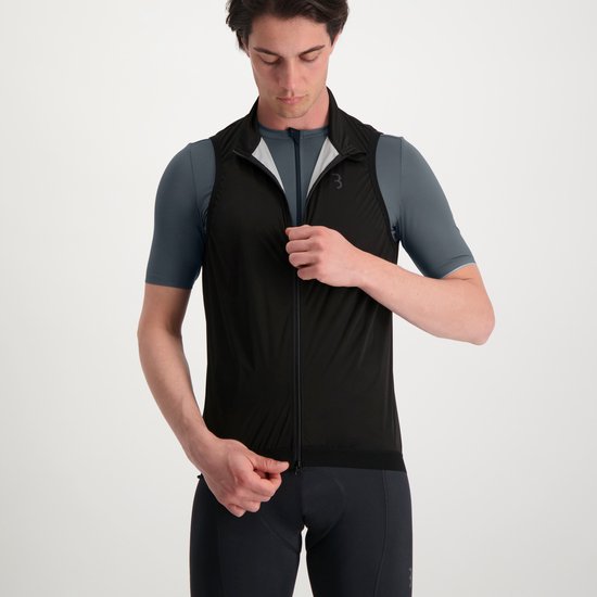 Man ritst zwarte mouwloze BBB fietsjas dicht boven donkergrijs fietsshirt.
