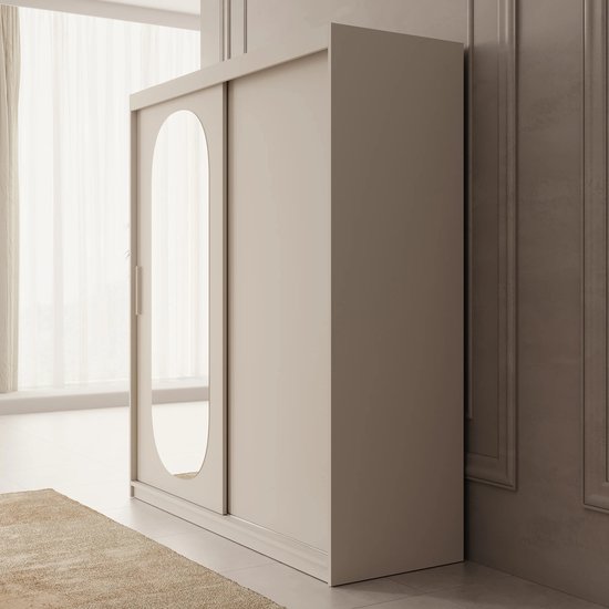 Zijaanzicht van een beige kledingkast met schuifdeuren, waarvan één deur een ovale spiegel heeft.