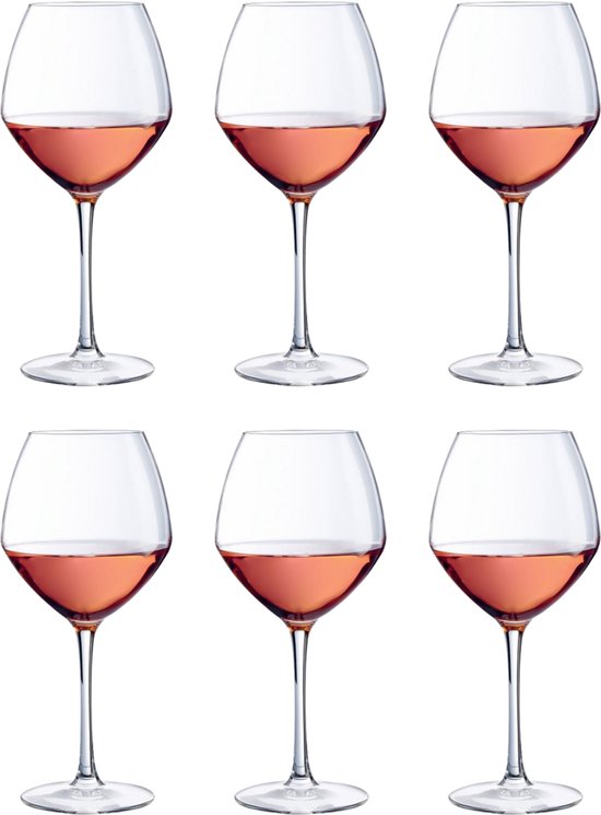 Six verres à vin contenant du vin rosé, chacun avec une tige fine et un calice évasé.