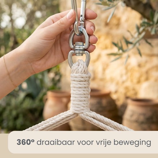 Hand die de metalen ophanging van een hangstoel vasthoudt.