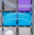 Close-up van de Connetix knikkerbaan, met blauwe glinsterende tegels en een gebogen transparante buis, met focus op de water-achtige vorm.