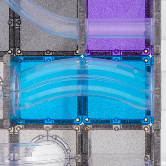 Close-up van de Connetix knikkerbaan, met blauwe glinsterende tegels en een gebogen transparante buis, met focus op de water-achtige vorm.