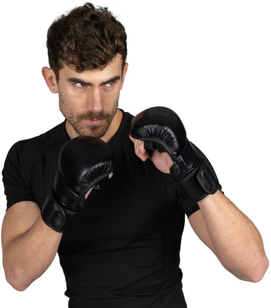 Man met zwarte MMA-handschoenen en een zwart shirt, in gevechtspositie.