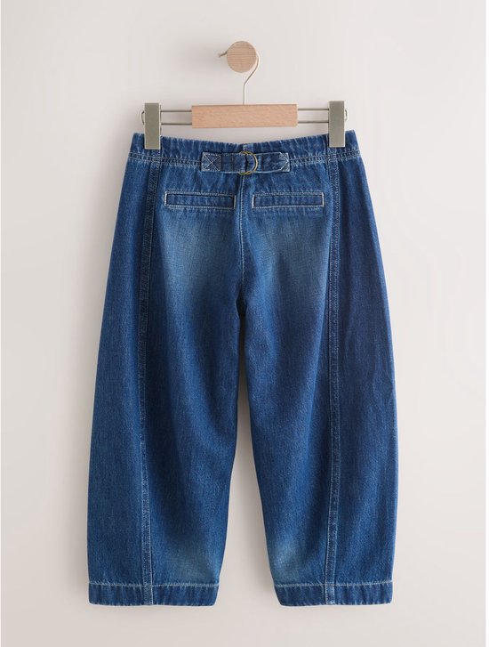 Achterkant van blauwe denim broek met gesp en verstelbare band.